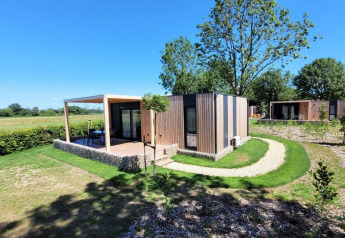 Photo du lodge Domus à Poort van Maastricht, Pays-Bas, entouré de verdure et de cabines modernes.