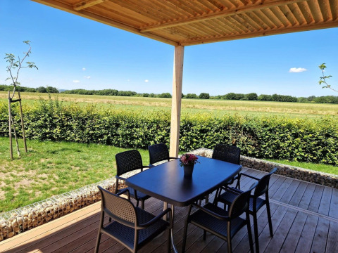 Zicht vanaf Domus in Poort van Maastricht, Nederland, met terras, stoelen, tafel en groene velden.