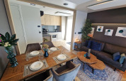 Modern living and kitchen area in tiny house Domus at Poort van Maastricht, Netherlands. Table set.