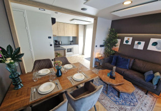 Modern living and kitchen area in tiny house Domus at Poort van Maastricht, Netherlands. Table set.