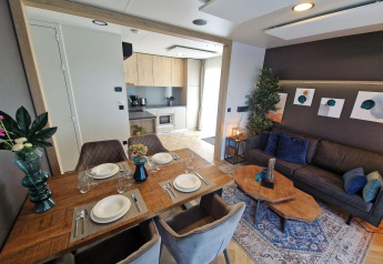 Moderne woonkamer en keuken in tiny house Domus bij Poort van Maastricht, Nederland. Tafel gedekt.