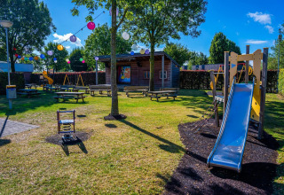 Colorido parque infantil con tobogán y columpios en Domus tiny house, Poort van Maastricht, Países Bajos.