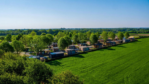Aerial view of tiny houses at Domus in Poort van Maastricht, Netherlands, set in lush green surroundings.