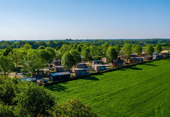 Luchtzicht op tiny houses in Domus, Poort van Maastricht, Nederland, omgeven door groene natuur.