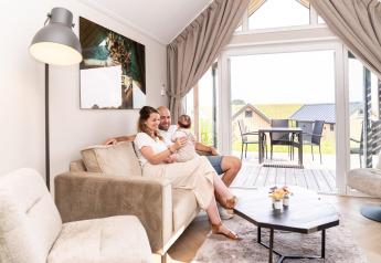 Una famiglia si rilassa nel soggiorno del Mountain Lodge presso Resort Mooi Bemelen nei Paesi Bassi.
