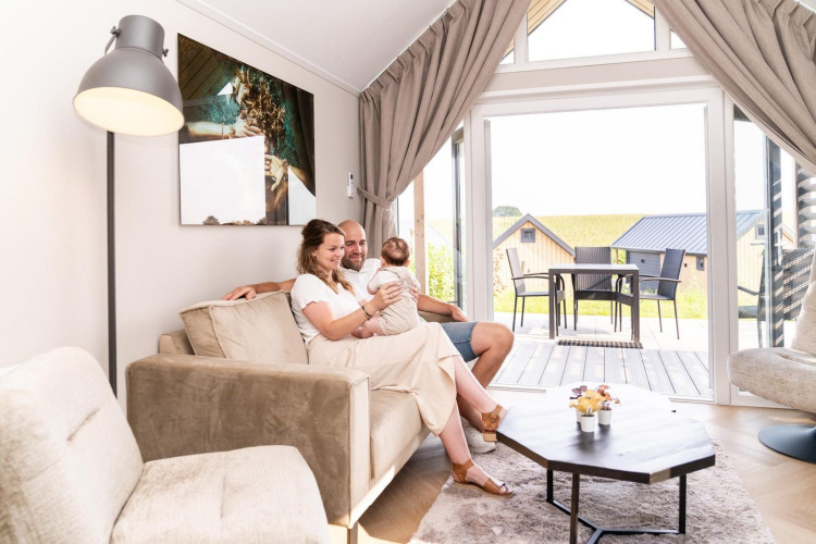 Una familia se relaja en la sala de estar de Mountain Lodge en el Resort Mooi Bemelen, Países Bajos.