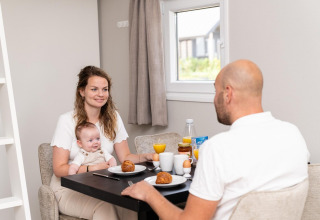 Una familia desayuna junta en una cabaña Mountain Lodge del Resort Mooi Bemelen en los Países Bajos.