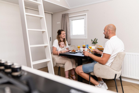 Familie genießt gemeinsam Frühstück am Tisch in der Mountain Lodge im Resort Mooi Bemelen, Niederlande.
