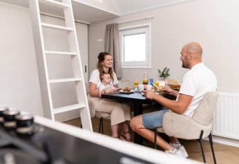 Famiglia che fa colazione insieme a un tavolo nella Mountain Lodge al Resort Mooi Bemelen, Paesi Bassi.