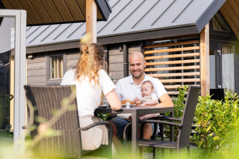 Familie frühstückt draußen am Mountain Lodge im Resort Mooi Bemelen in den Niederlanden.
