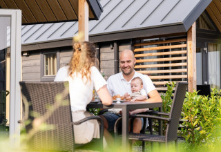 Familie frühstückt draußen am Mountain Lodge im Resort Mooi Bemelen in den Niederlanden.