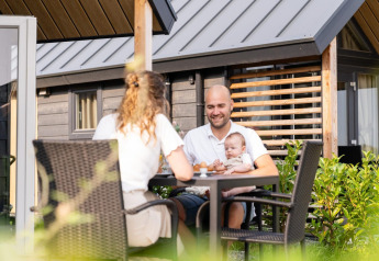 Familie frühstückt draußen am Mountain Lodge im Resort Mooi Bemelen in den Niederlanden.