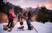 Personas cocinando sobre fuego al aire libre en la nieve en Huttopia la Clarée, Provenza-Alpes-Côte d’Azur.