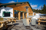 Terraza exterior con bancos de madera en Les Chalets Huttopia de Font-Romeu, situado en Occitanie, Francia.
