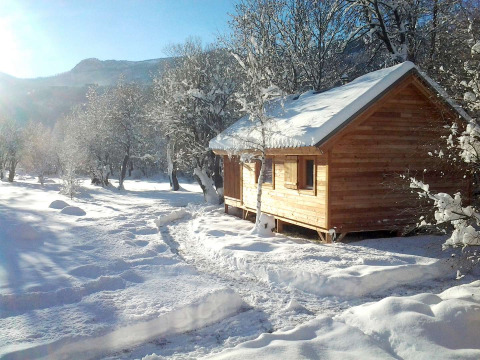 Houten chalet in de sneeuw tussen bomen in Vallouise, Provence-Alpes-Côte d’Azur, Frankrijk in de winter.