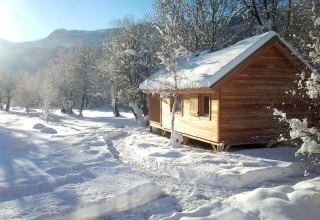 Wooden cabin covered in snow among trees at Vallouise, Provence-Alpes-Côte d’Azur, France in wintertime.
