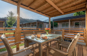 Terrasse en bois couverte avec table et chaises au Cottage Hermagor-Nassfeld, Autriche, vue sur les montagnes.
