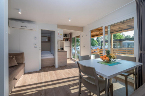 Moderne stue i en Cottage på Hermagor-Nassfeld i Østrig med spisebord, sofa og udsigt til terrasse.