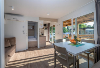 Sala moderna en una Cottage en Hermagor-Nassfeld, Austria, con mesa de comedor, sofá y terraza exterior.