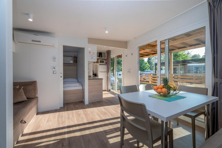 Sala moderna en una Cottage en Hermagor-Nassfeld, Austria, con mesa de comedor, sofá y terraza exterior.