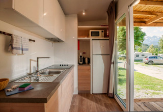 Moderne Küche in einer Hütte in Hermagor-Nassfeld, Österreich, mit Blick auf Campingplatz und Berge.