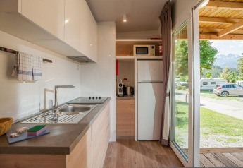 Cocina moderna en una cabaña de Hermagor-Nassfeld, Austria, con vistas al camping y las montañas.