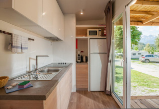 Cocina moderna en una cabaña de Hermagor-Nassfeld, Austria, con vistas al camping y las montañas.