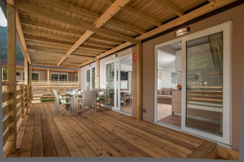 Terraza de madera con comedor en Cottage en Hermagor-Nassfeld, Austria; ambiente moderno y acogedor.