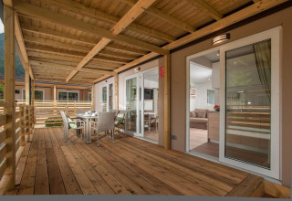 Terraza de madera con comedor en Cottage en Hermagor-Nassfeld, Austria; ambiente moderno y acogedor.