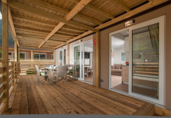 Terraza de madera con comedor en Cottage en Hermagor-Nassfeld, Austria; ambiente moderno y acogedor.