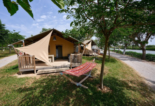 Tenda safari Villatent Wood al Camping Nautic Almata in Spagna, veranda ombreggiata e vista sul fiume.