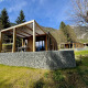 Panorama Lodge ved Pressegger See i Østrig med moderne træhytter, terrasse og bjergudsigt om foråret.