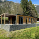 Panorama Lodge ved Pressegger See i Østrig omgivet af bjerge og skov med solrig terrasse og have.
