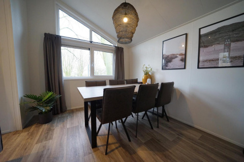 Moderne eetkamer in Hackfort-lodge bij Vakantiepark Aan de Maas, Nederland, met acht stoelen.