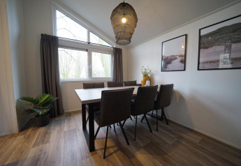 Moderne eetkamer in Hackfort-lodge bij Vakantiepark Aan de Maas, Nederland, met acht stoelen.