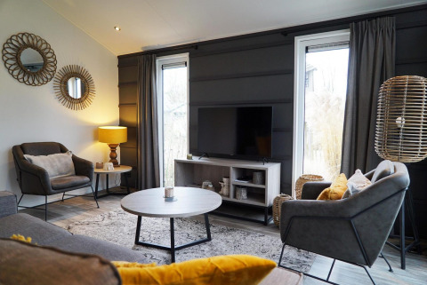 Sala moderna en la cabaña Hackfort de Vakantiepark Aan de Maas, Países Bajos, con una decoración elegante y luz natural.