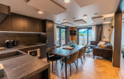 Moderne woon- en keukenruimte in de Wulfenia-lodge met bergzicht door grote ramen.