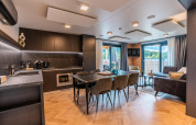Moderne keuken en zitruimte in Wulfenia-lodge bij de Ossiacher See, Oostenrijk, met uitzicht op de natuur.