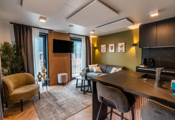 Sala de estar moderna en la Seerose lodge junto al lago Ossiacher See, Austria, con decoración elegante y cocina.