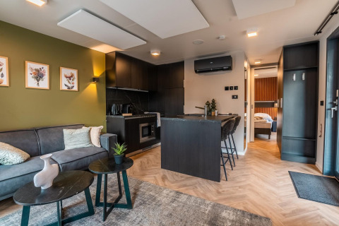 Lodge moderno Seerose en Ossiacher See, Austria, con sala, cocina, comedor y vista hacia el dormitorio.