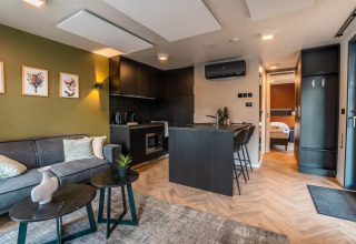 Lodge moderno Seerose en Ossiacher See, Austria, con sala, cocina, comedor y vista hacia el dormitorio.