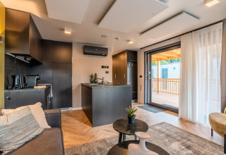 Lodge moderne Seerose au lac Ossiacher See en Autriche avec salon élégant, cuisine ouverte et terrasse.