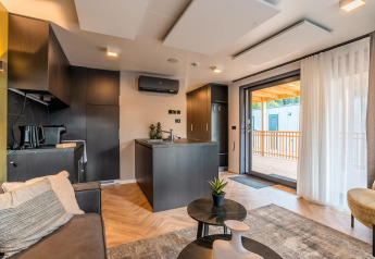 Lodge Seerose moderno en Ossiacher See, Austria, con sala elegante, cocina abierta y terraza exterior.