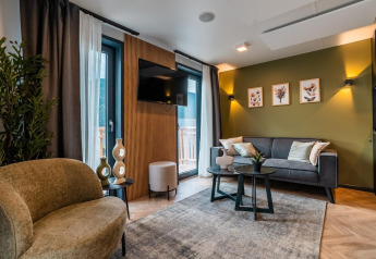 Salon moderne du lodge Seerose près du lac Ossiacher See en Autriche, avec décoration élégante et mur vert.