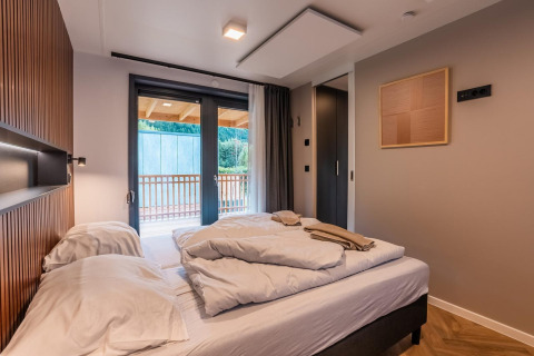 Moderne slaapkamer in lodge Seerose aan de Ossiacher See in Oostenrijk met dubbel bed en balkon.