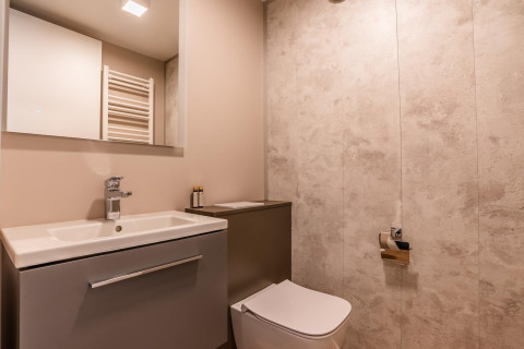 Salle de bain moderne de la lodge Seerose au lac Ossiacher, Autriche, avec lavabo, miroir et WC.