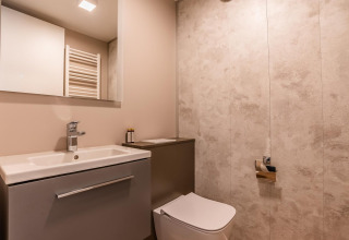 Salle de bain moderne de la lodge Seerose au lac Ossiacher, Autriche, avec lavabo, miroir et WC.