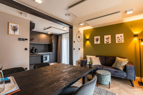 Moderne lodge aan het Ossiacher Meer in Oostenrijk, met open leefruimte, keuken en groene accentmuurkunst.