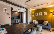 Alojamiento moderno en Ossiacher See, Austria, con sala abierta, cocina y pared verde decorada con arte floral.