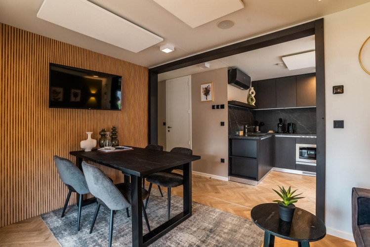 Moderne eet- en woonkamer bij Enzian lodge aan Ossiacher See, Oostenrijk, met een strakke keuken op de achtergrond.